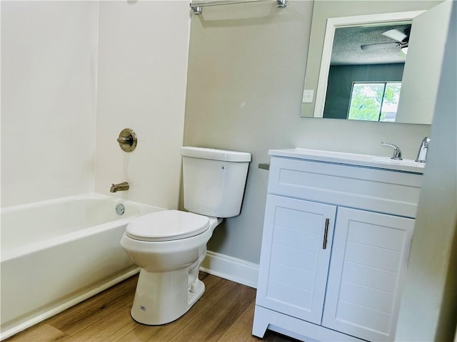 full bathroom featuring vanity, wood finished floors, toilet, baseboards, and shower / washtub combination