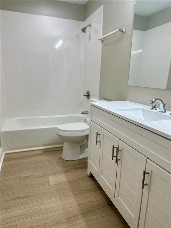bathroom with vanity, shower / bathing tub combination, toilet, and wood finished floors