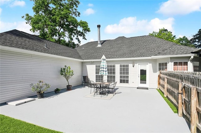 back of house featuring a patio area, fence, and roof with shingles