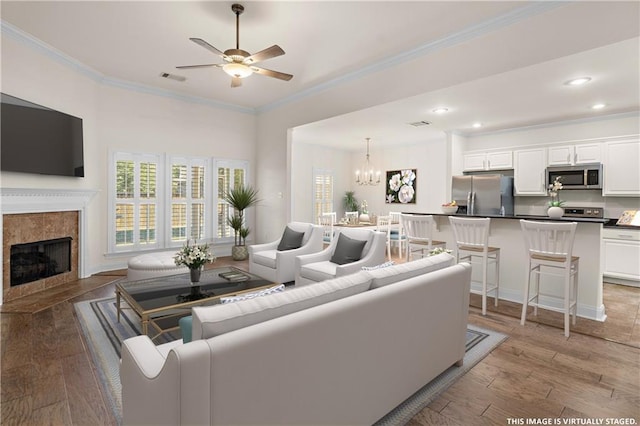 940 Woodsprings Ct, Covington, LA 70433 - living area featuring a ceiling fan, a premium fireplace, crown molding, light wood finished floors, and a chandelier