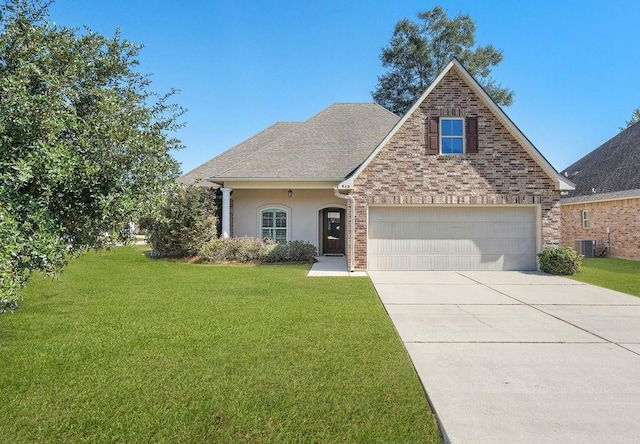 940 Woodsprings Ct, Covington, LA 70433 - traditional-style house with a front lawn, concrete driveway, a garage, and stucco siding