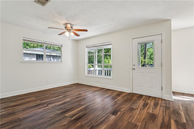 interior space with visible vents, wood finished floors, baseboards, a textured ceiling, and a ceiling fan