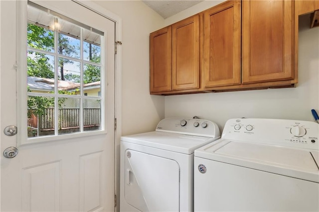 clothes washing area with washing machine and clothes dryer and cabinet space