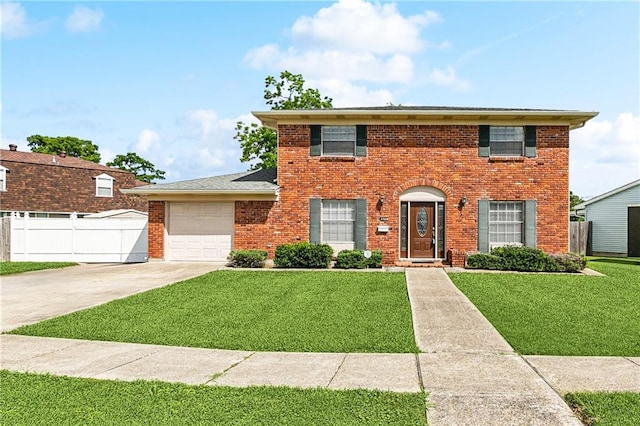 colonial home with fence, concrete driveway, and a front yard