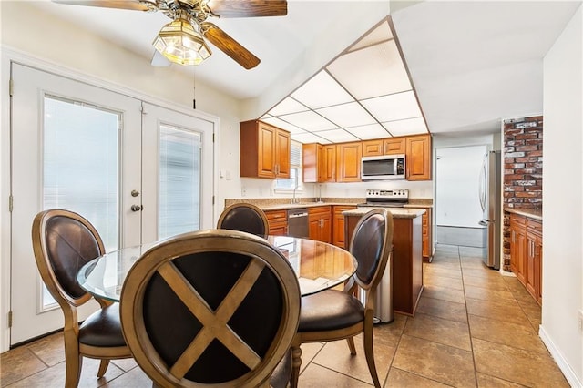 dining space with french doors, ceiling fan, a paneled ceiling, and baseboards