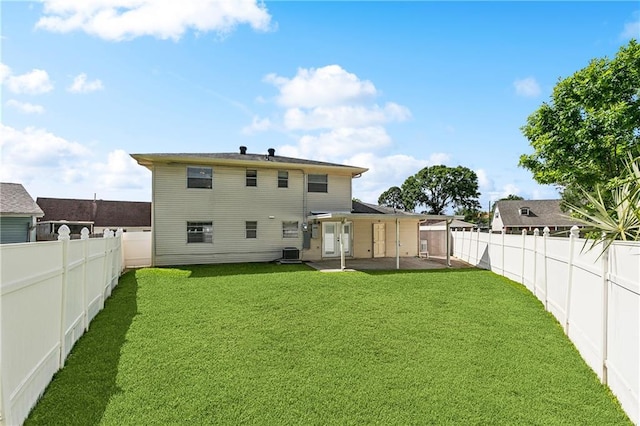 rear view of house featuring a lawn, a patio, a fenced backyard, and central AC