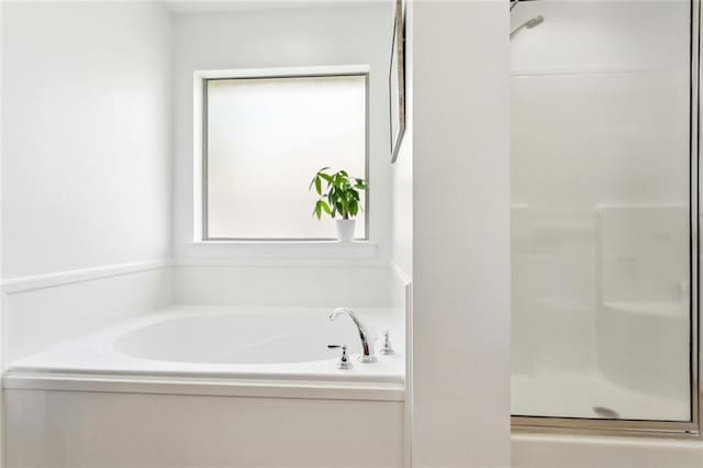 bathroom featuring a bath and a stall shower