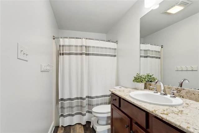 bathroom featuring vanity, toilet, curtained shower, wood finished floors, and visible vents
