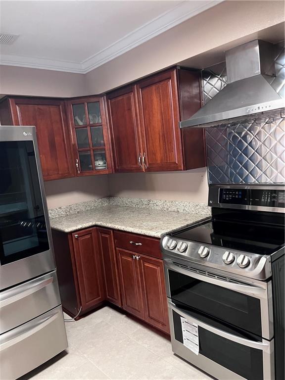 kitchen with double oven range, visible vents, crown molding, smart refrigerator, and wall chimney exhaust hood