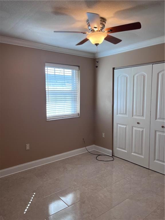 unfurnished bedroom featuring crown molding, ceiling fan, and a closet