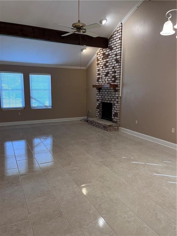 unfurnished living room with a ceiling fan, crown molding, a brick fireplace, baseboards, and lofted ceiling