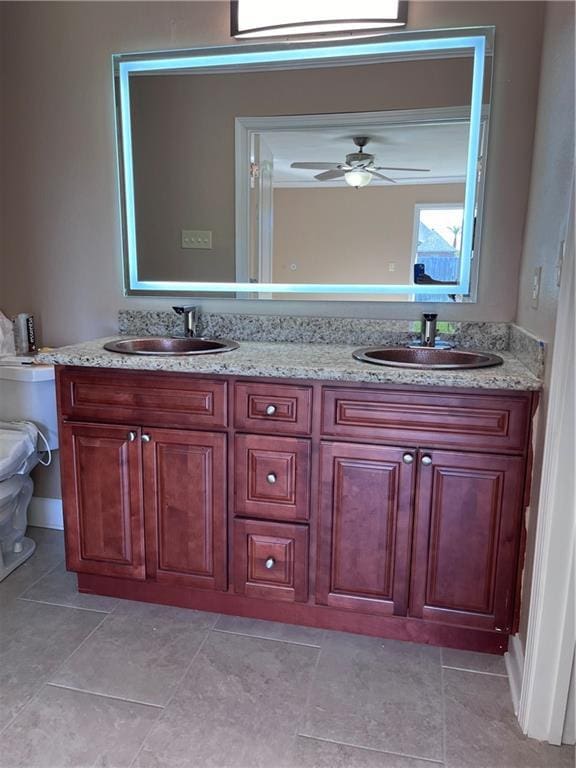 bathroom featuring double vanity, a ceiling fan, and a sink