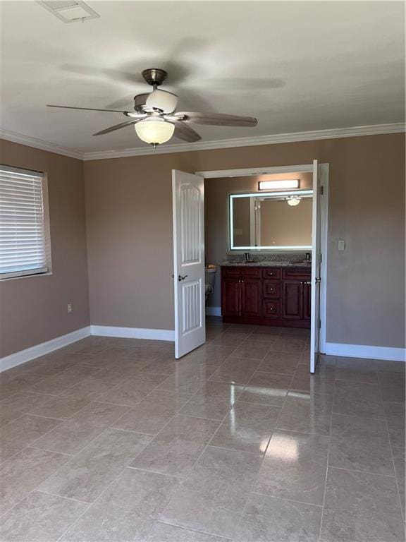 empty room featuring baseboards, ornamental molding, a ceiling fan, and visible vents