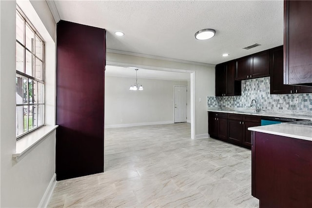 kitchen with visible vents, tasteful backsplash, light countertops, a sink, and a chandelier