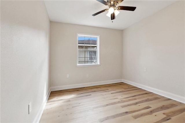 empty room with a ceiling fan, baseboards, and wood finished floors