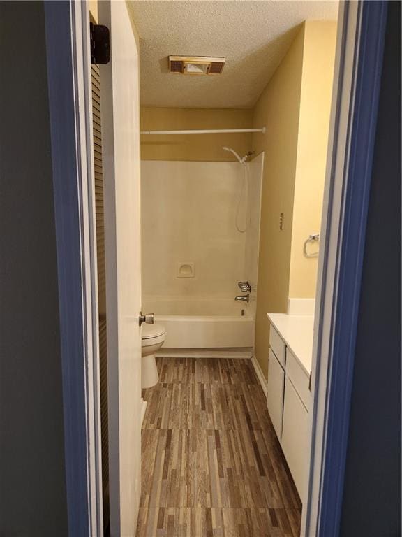 full bath featuring vanity, toilet, bathing tub / shower combination, wood finished floors, and visible vents