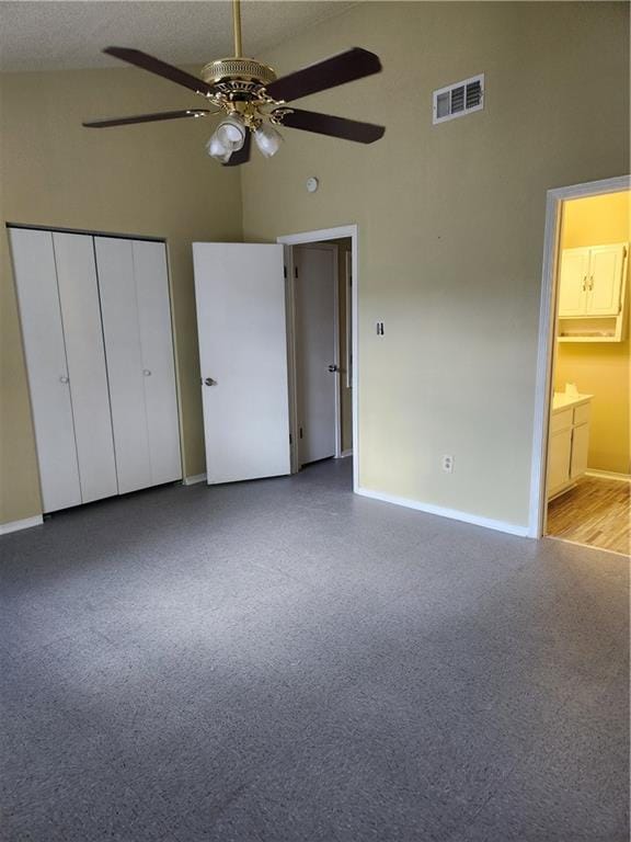 unfurnished bedroom featuring ceiling fan, visible vents, high vaulted ceiling, baseboards, and a closet