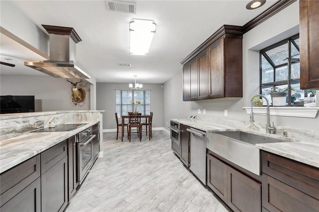 kitchen featuring visible vents, appliances with stainless steel finishes, a sink, light stone counters, and light wood-style floors