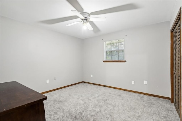 unfurnished bedroom featuring a closet, carpet flooring, baseboards, and ceiling fan