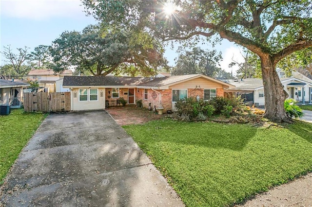 ranch-style house featuring fence, driveway, a front lawn, and brick siding