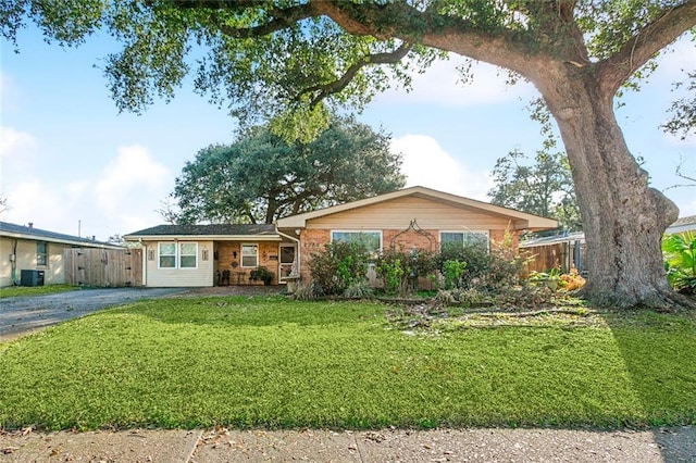 ranch-style home featuring fence, a front lawn, brick siding, aphalt driveway, and central air condition unit