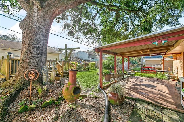 view of yard with a fenced backyard, a deck, and outdoor dining space
