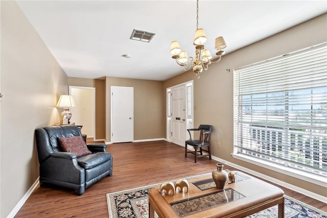living room with wood finished floors, baseboards, a chandelier, and visible vents