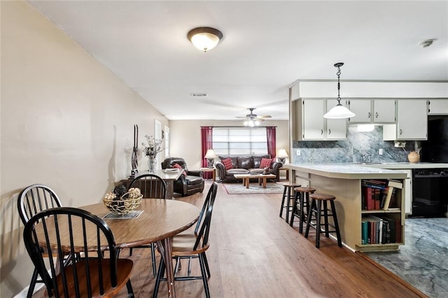 dining space featuring a ceiling fan and wood finished floors