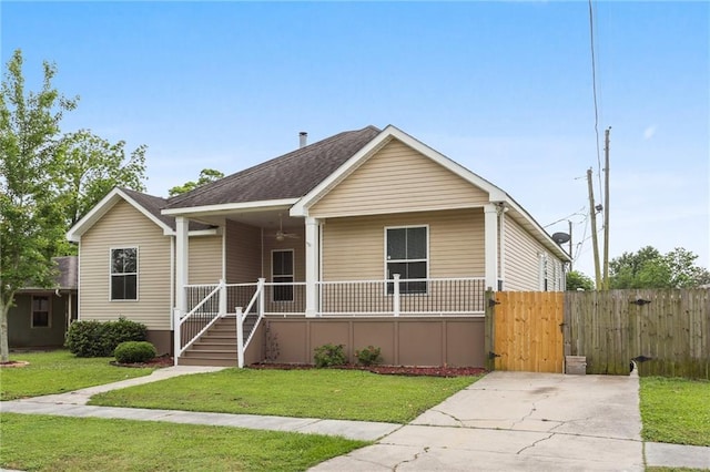 bungalow-style home with fence, roof with shingles, a front lawn, a gate, and covered porch