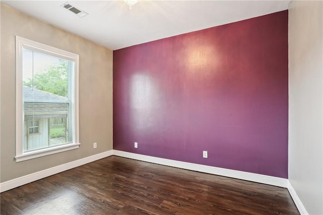 empty room with baseboards, dark wood-style floors, and a healthy amount of sunlight