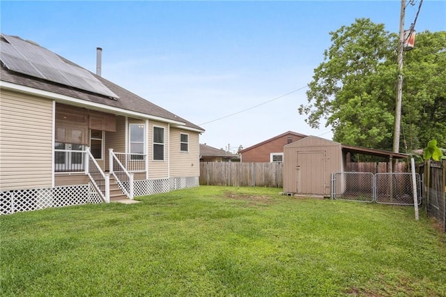 view of yard with a fenced backyard, a storage unit, and an outbuilding