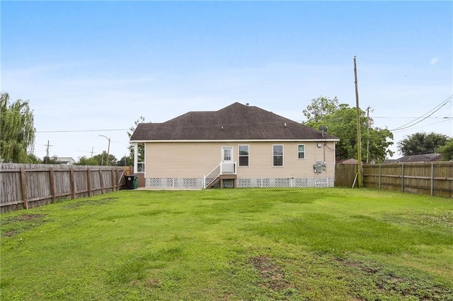 rear view of property with a lawn and a fenced backyard