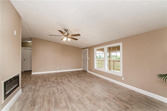 32536 D Wascom Rd, Mount Hermon, LA 70450 - unfurnished living room with a ceiling fan, a textured ceiling, baseboards, heating unit, and light wood-style flooring