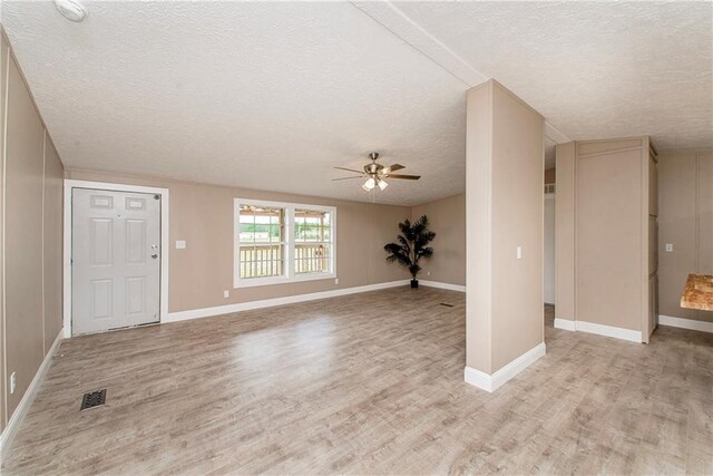 32536 D Wascom Rd, Mount Hermon, LA 70450 - unfurnished living room with baseboards, ceiling fan, light wood-type flooring, and a textured ceiling