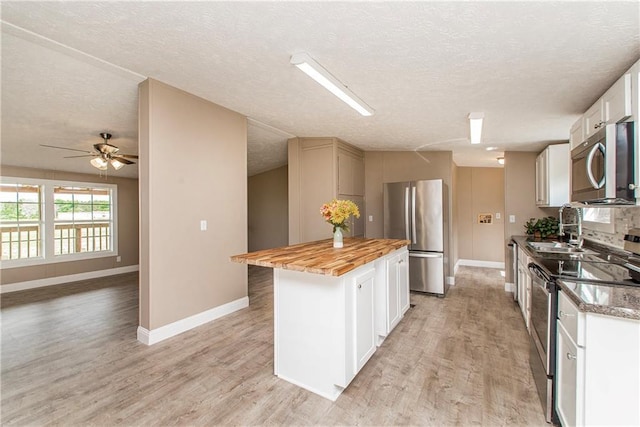 32536 D Wascom Rd, Mount Hermon, LA 70450 - kitchen featuring a sink, a textured ceiling, appliances with stainless steel finishes, and wooden counters
