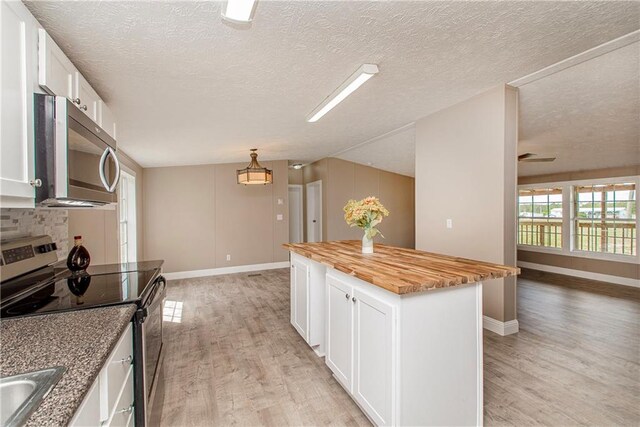 32536 D Wascom Rd, Mount Hermon, LA 70450 - kitchen with light wood-type flooring, wood counters, appliances with stainless steel finishes, and white cabinetry