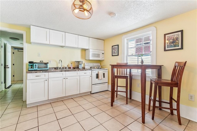 1818 Paul Morphy St, New Orleans, LA 70119 - kitchen with a textured ceiling, a sink, white cabinets, white appliances, and light tile patterned flooring