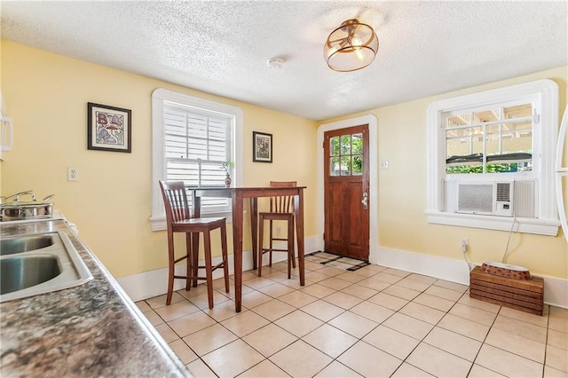 1818 Paul Morphy St, New Orleans, LA 70119 - dining room with light tile patterned floors, baseboards, cooling unit, and a textured ceiling