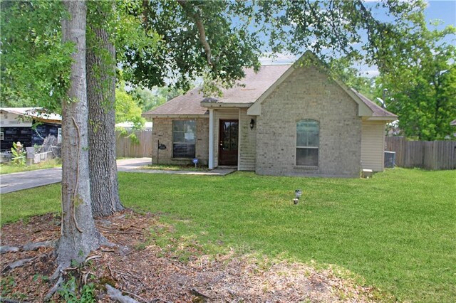 57288 Beech Ave, Slidell, LA 70461 - view of front facade with brick siding, fence, and a front lawn
