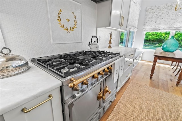 34 Riverdale Dr, Covington, LA 70433 - kitchen with range with two ovens, light wood finished floors, light countertops, and white cabinets