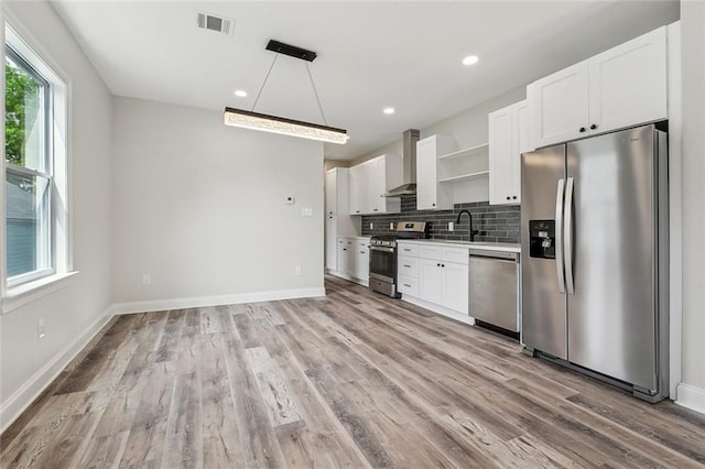 kitchen with a healthy amount of sunlight, open shelves, stainless steel appliances, and wall chimney exhaust hood