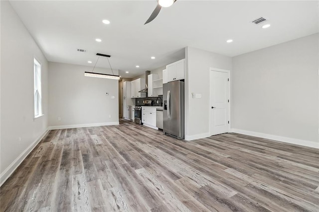 unfurnished living room with a ceiling fan, visible vents, wood finished floors, and recessed lighting