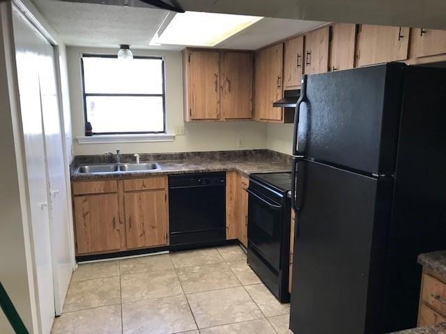 47 Birdie Dr Unit 7, Slidell, LA 70460 - kitchen with dark countertops, under cabinet range hood, a sink, light tile patterned floors, and black appliances