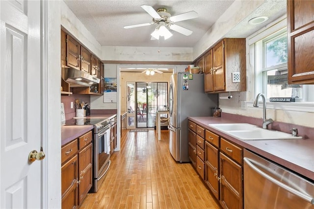 2004 Harvard Ave, Metairie, LA 70001 - kitchen with appliances with stainless steel finishes, a sink, ceiling fan, brown cabinets, and light wood-style floors
