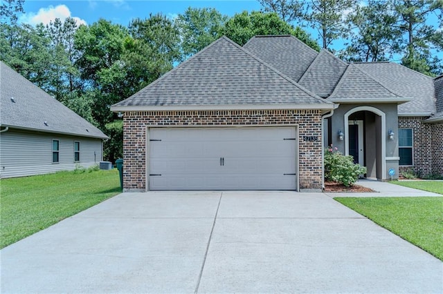 47135 Vineyard Trce, Hammond, LA 70401 - view of front of house with an attached garage, a front lawn, roof with shingles, and brick siding