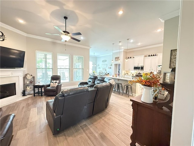 318 Saw Grass Loop, Covington, LA 70435 - living room featuring a ceiling fan, ornamental molding, light wood-type flooring, a fireplace with flush hearth, and recessed lighting