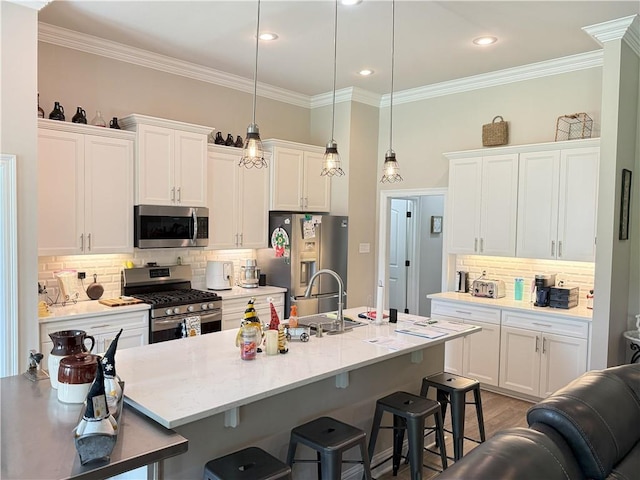318 Saw Grass Loop, Covington, LA 70435 - kitchen with appliances with stainless steel finishes, a breakfast bar area, decorative backsplash, ornamental molding, and white cabinets