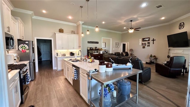 318 Saw Grass Loop, Covington, LA 70435 - kitchen featuring appliances with stainless steel finishes, open floor plan, a sink, white cabinets, and ceiling fan