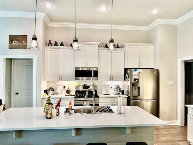 318 Saw Grass Loop, Covington, LA 70435 - kitchen with appliances with stainless steel finishes, a breakfast bar, crown molding, decorative backsplash, and white cabinets