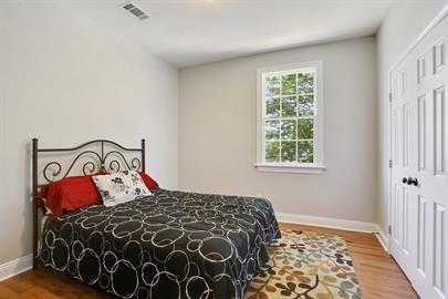 bedroom featuring baseboards, wood finished floors, and visible vents